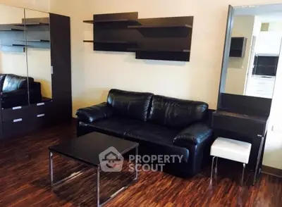 Modern living room with sleek black leather sofa and stylish shelving, perfect for contemporary urban living.