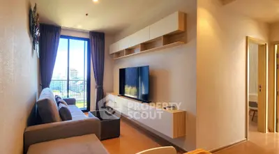 Modern living room with large TV, stylish shelving, and city view from window.