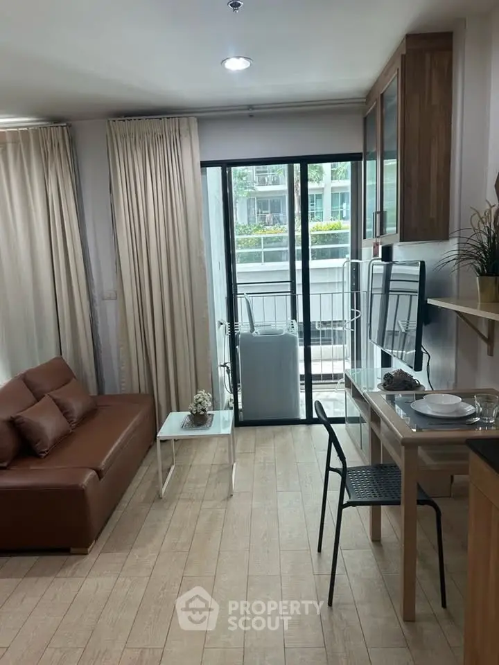 Modern living room with balcony access and stylish furniture in a cozy apartment.