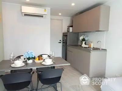 Modern kitchen with dining area featuring sleek cabinets and elegant table setting