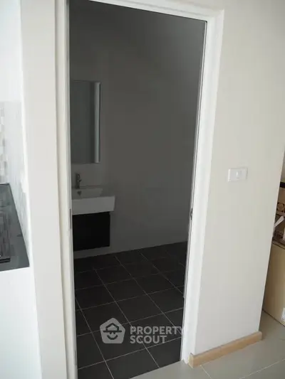 Modern bathroom with sleek sink and tiled floor in a contemporary home.