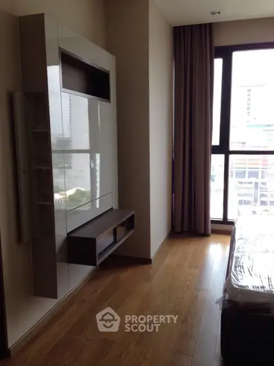 Modern bedroom with sleek built-in storage and large window view.