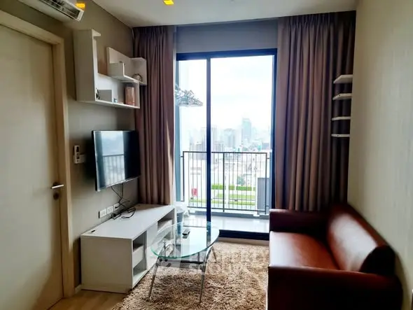 Modern living room with balcony and city view, featuring sleek furniture and stylish decor.