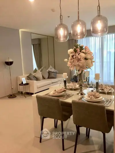 Elegant dining and living area with modern decor and soft lighting in a stylish apartment.