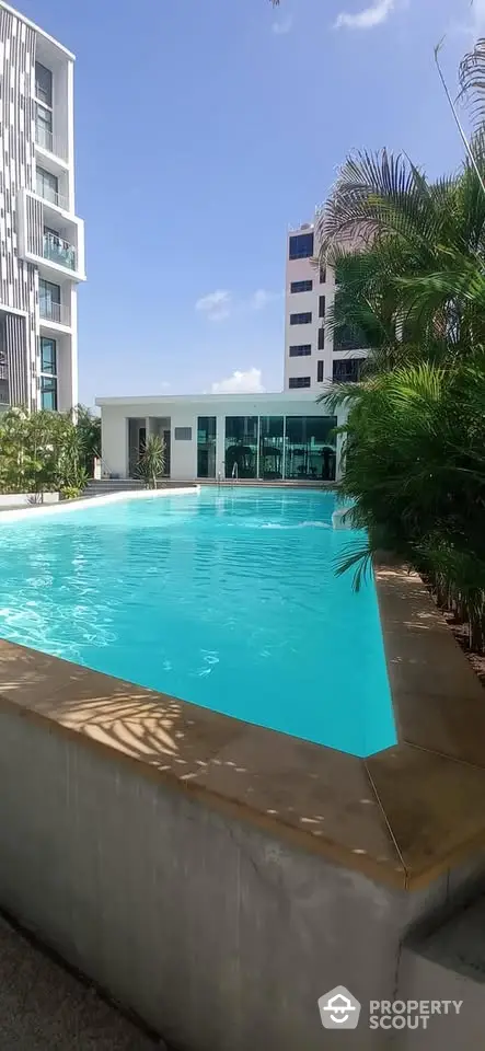 Luxurious residential pool area with modern architecture and lush greenery