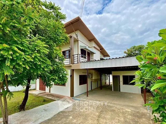 Charming two-story house with spacious driveway and lush greenery, perfect for family living.