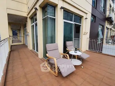 Spacious balcony with cozy seating and city views, perfect for relaxation and entertaining.