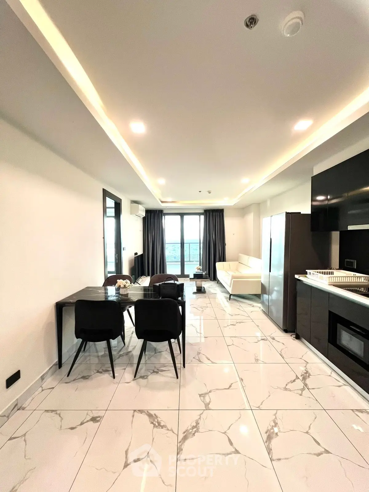 Modern open-layout living room with sleek kitchen, marble flooring, and large windows.