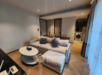 Modern living room with stylish furniture and open kitchen layout.