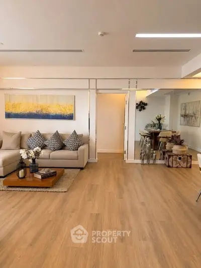Spacious modern living room with elegant decor and wooden flooring, perfect for relaxation and entertainment.