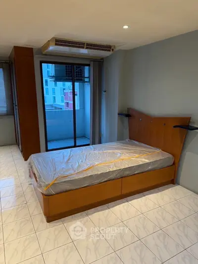 Modern bedroom with balcony access and sleek tile flooring