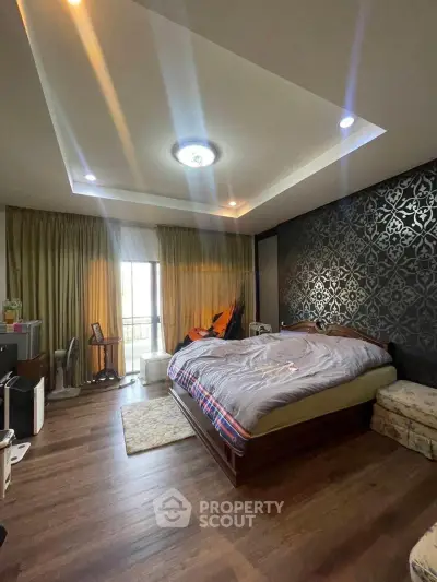Spacious bedroom with elegant decor and large window for natural light