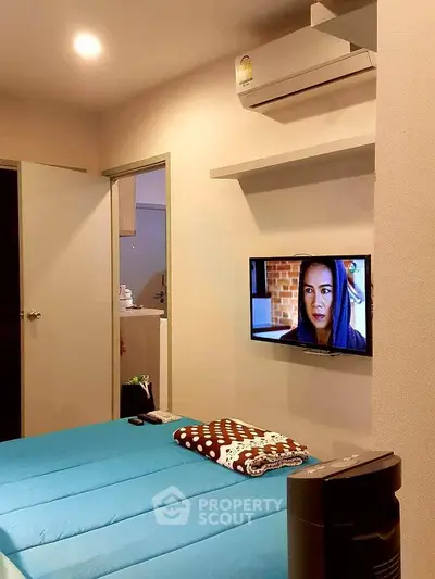 Cozy bedroom with modern air conditioning and wall-mounted TV, perfect for relaxation.