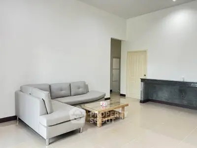 Spacious modern living room with sleek gray sofa and elegant coffee table.