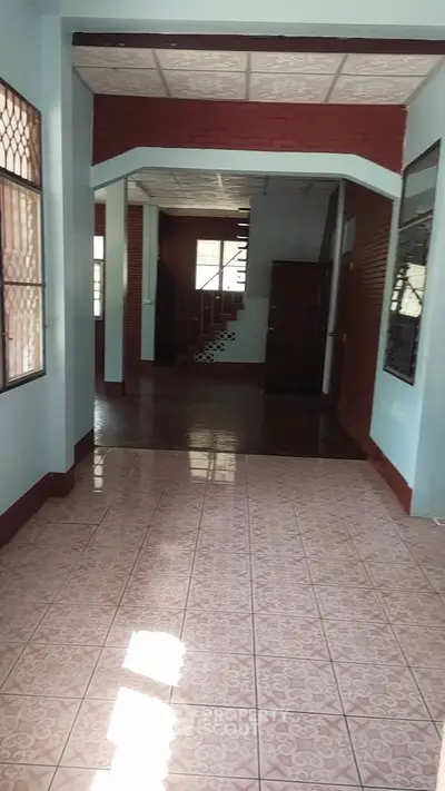 Spacious interior with tiled floors and staircase, ideal for customization.