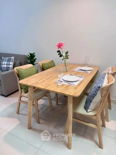 Modern dining area with wooden table and chairs, stylish decor, and cozy ambiance.
