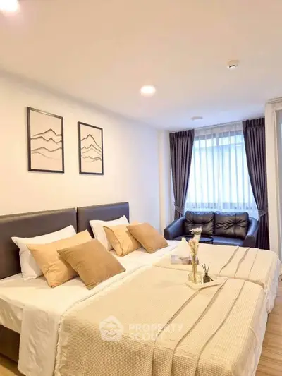 Spacious bedroom with twin beds and cozy seating area, perfect for relaxation.