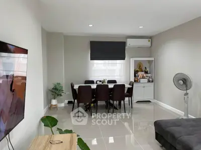 Modern living room with dining area, sleek furniture, and air conditioning.