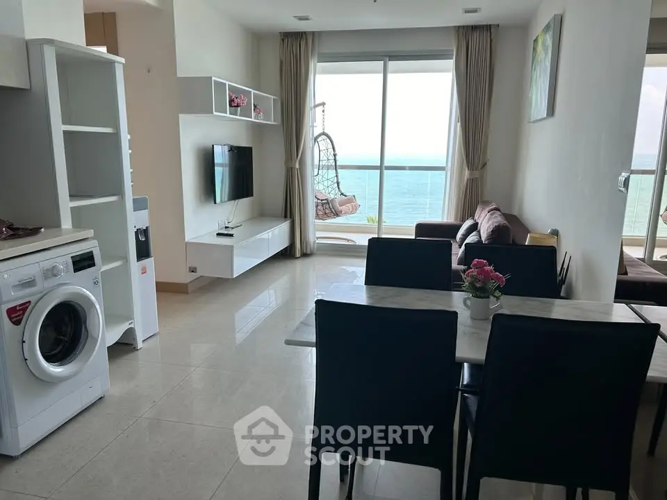 Modern living room with ocean view, stylish furniture, and open layout in a high-rise apartment.