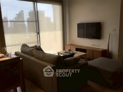 Cozy living room with modern decor and city view through large window.
