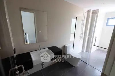 Modern bathroom with sleek fixtures and large mirror in contemporary home
