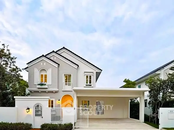 Charming two-story house with elegant facade and spacious driveway in a serene neighborhood.