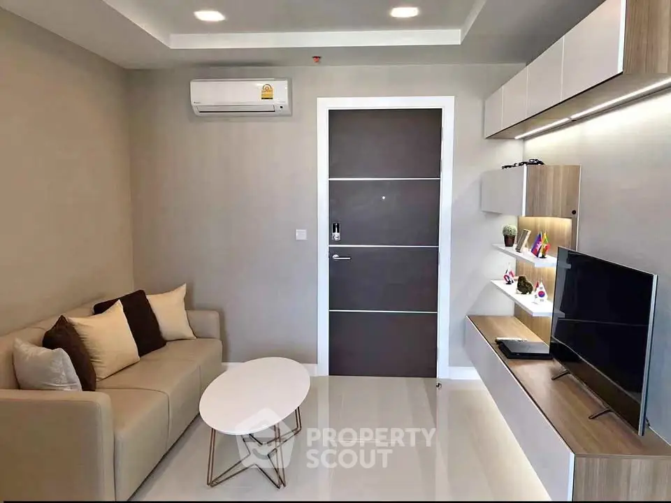 Modern living room with sleek furniture and wall-mounted TV in a stylish apartment.