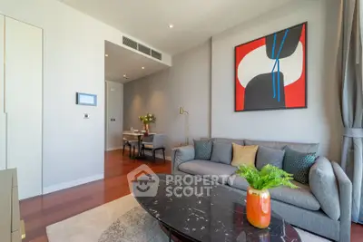 Modern living room with stylish decor and vibrant artwork, featuring a cozy gray sofa and elegant marble coffee table.