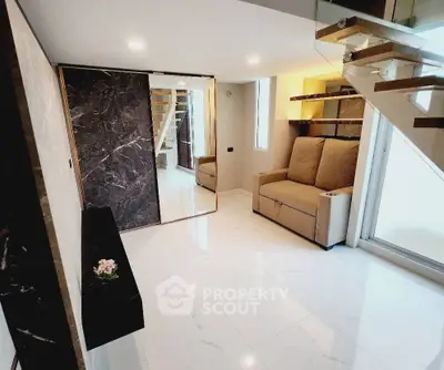 Modern living room with sleek staircase and marble accents