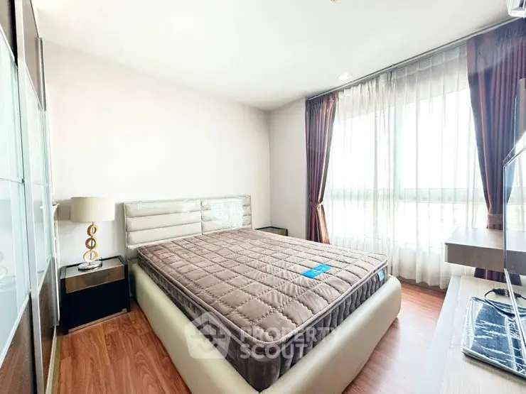 Bright and cozy bedroom with large window and modern furnishings
