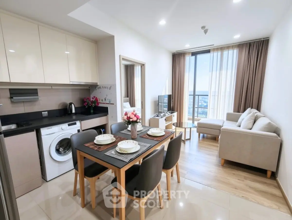 Modern open-plan living room and kitchen with stylish furniture and city view.