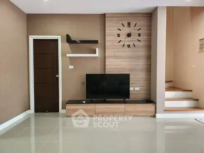 Modern living room with sleek TV setup and stylish wall clock