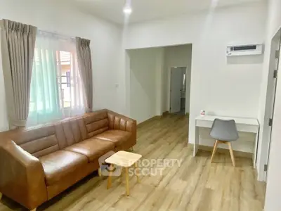 Modern living room with leather sofa and wooden flooring