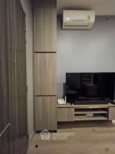 Modern living room with sleek TV setup and air conditioning unit