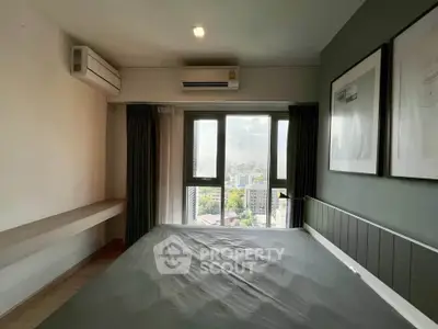 Modern bedroom with city view, featuring sleek design and large window for natural light.