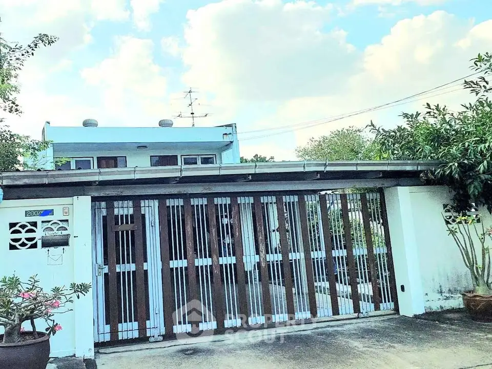Charming single-story home with gated entrance and lush greenery, perfect for privacy and tranquility.