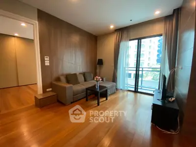 Spacious modern living room with wooden flooring and large window balcony view.