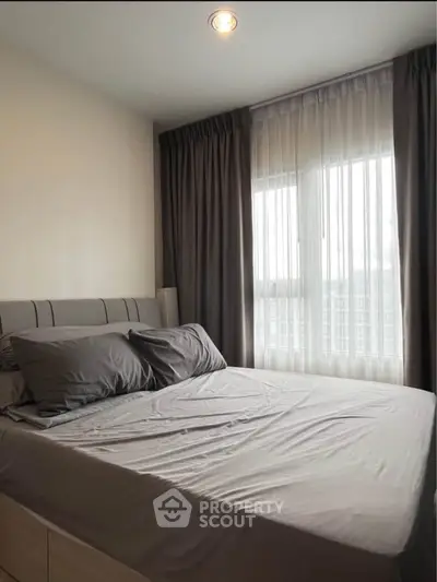 Cozy bedroom with modern decor and large window for natural light
