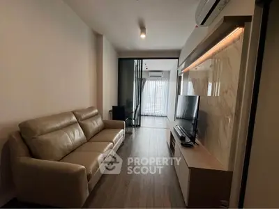 Modern living room with sleek design, featuring a comfortable sofa and large TV, perfect for relaxation.