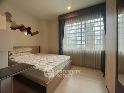 Cozy bedroom with large window and modern decor in a stylish apartment.