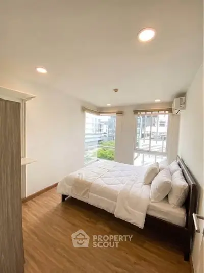 Bright and airy bedroom with large windows and modern decor in a stylish apartment.