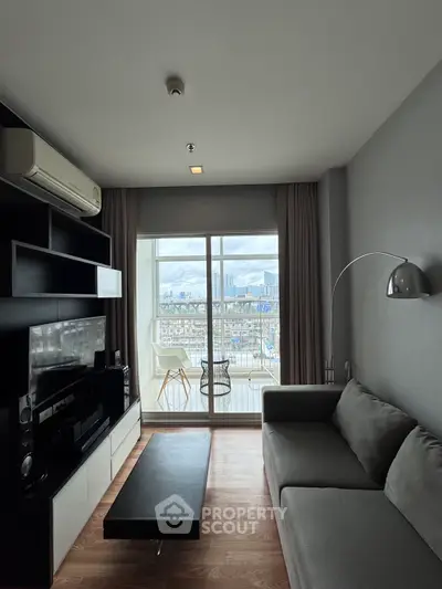 Modern living room with city view, sleek furniture, and large window for natural light.