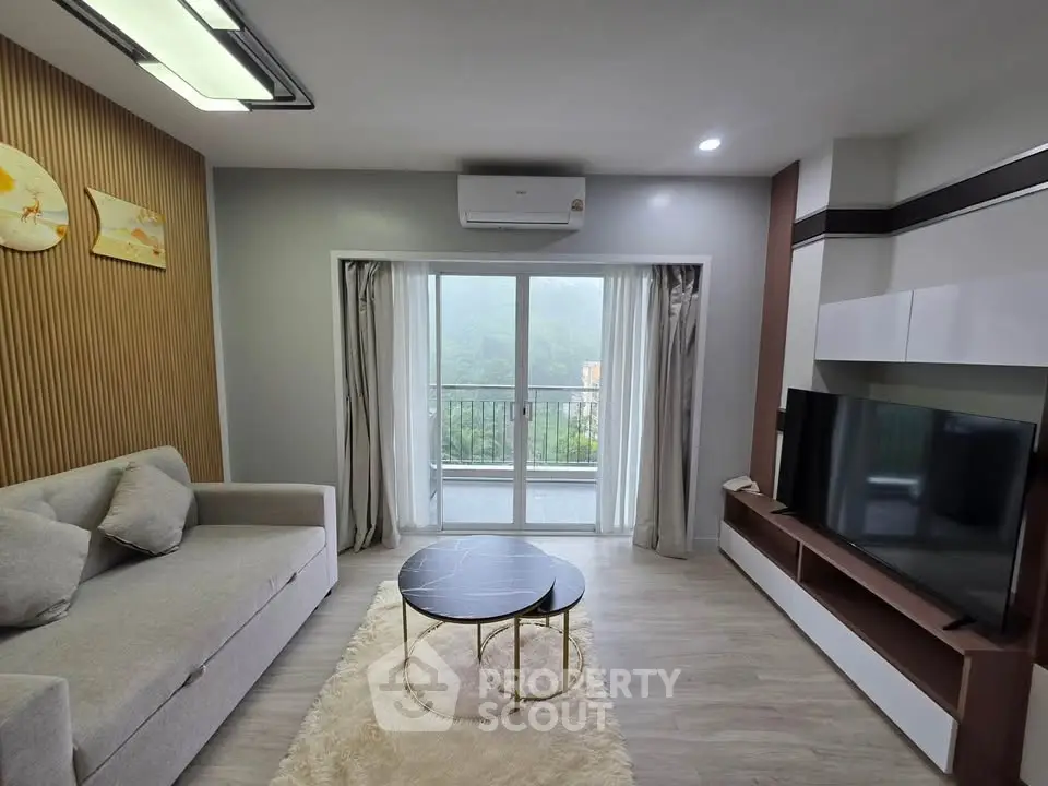 Modern living room with stylish decor and balcony view, featuring a cozy sofa and sleek entertainment unit.