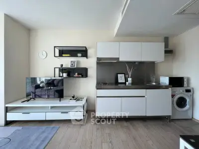 Modern living room with sleek kitchen and washing machine, perfect for urban living.