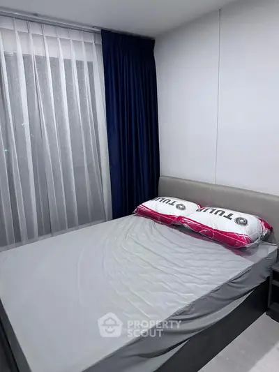 Cozy bedroom with modern decor and stylish curtains, perfect for relaxation.