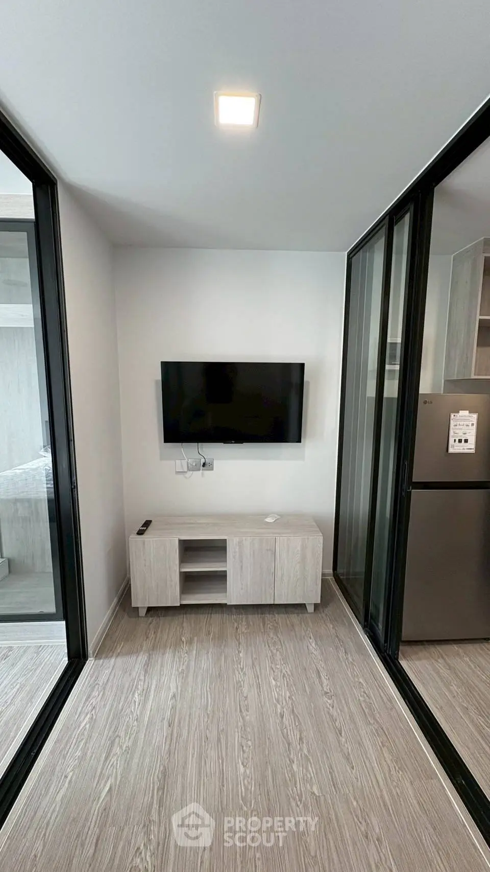 Modern living room with sleek TV setup and sliding glass doors