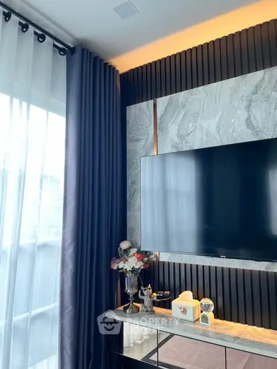 Modern living room with elegant decor and large TV on marble accent wall