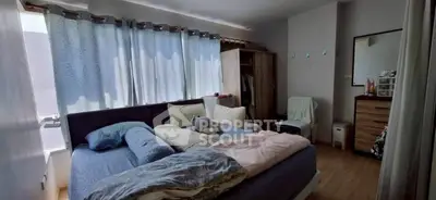 Cozy bedroom with large window and stylish decor, perfect for relaxation and comfort.