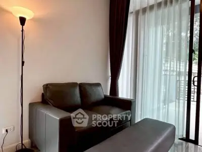 Cozy living room with leather sofa and floor lamp near large window