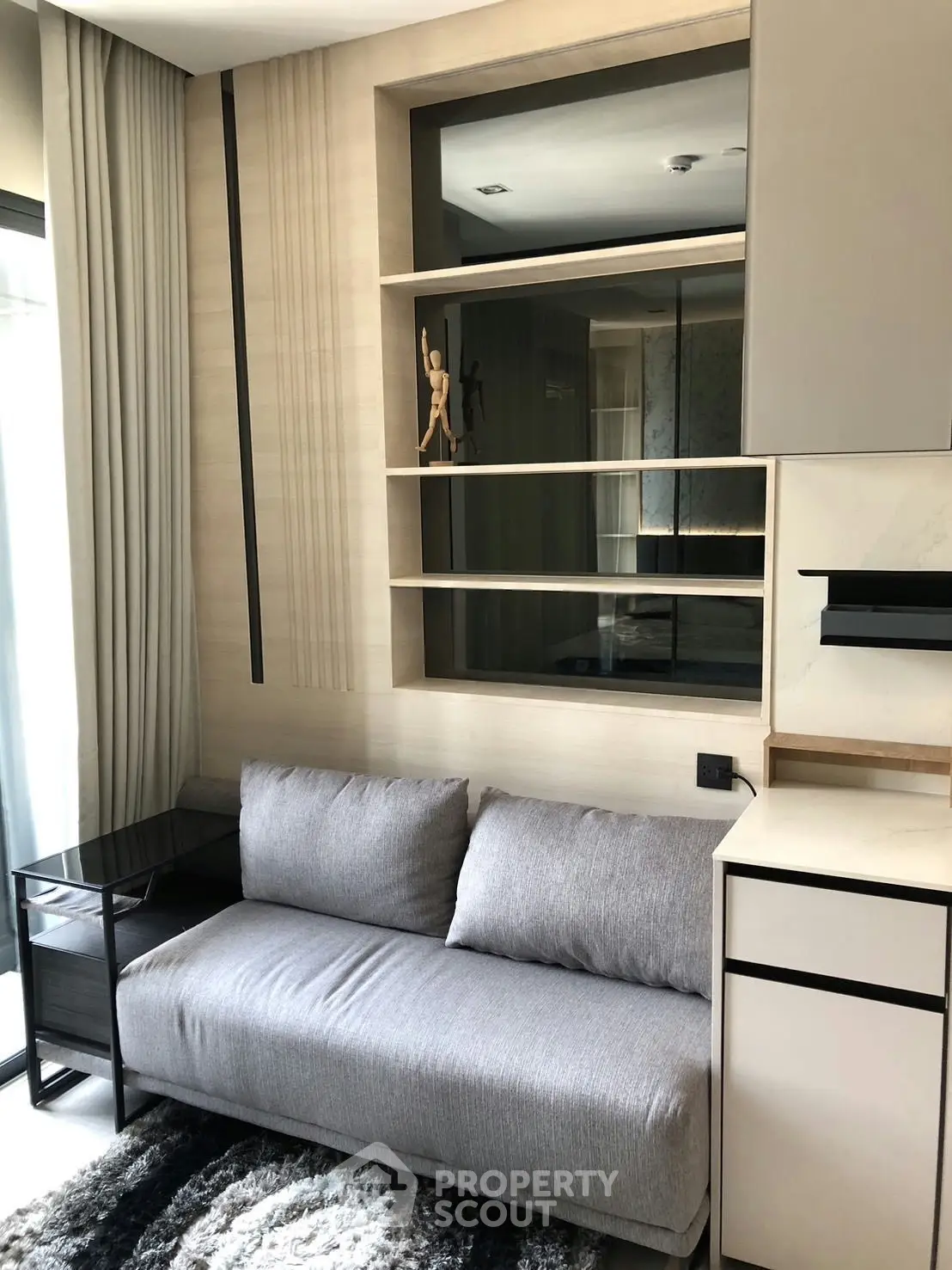 Modern living room with sleek sofa and stylish shelving in a contemporary apartment.